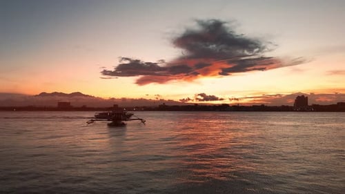 Boats Silhouetted Against Dramatic Sunset Over City Waterfront