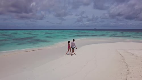 Couple Walking on White Sand in the Maldives