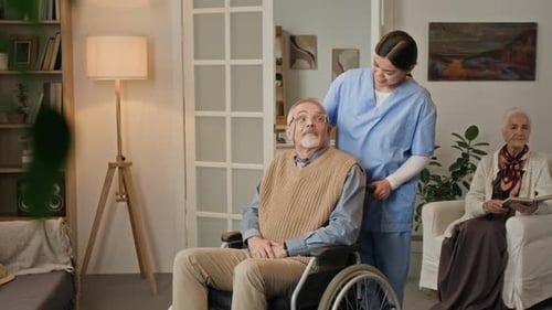 Friendly Caregiver Assists Senior Man in Wheelchair
