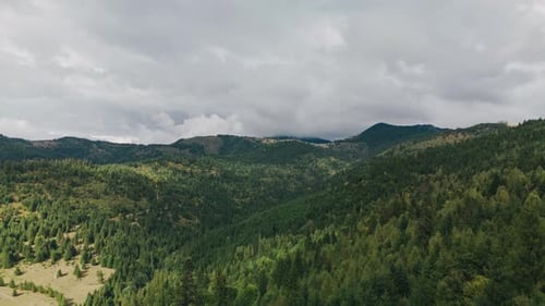 Breathtakingly Lush Green Mountains Stretching Under an Overcast Cloudy Sky Above