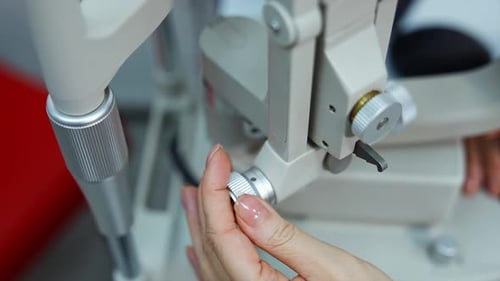 Hand Adjusting Eye Exam Machine in Clinic