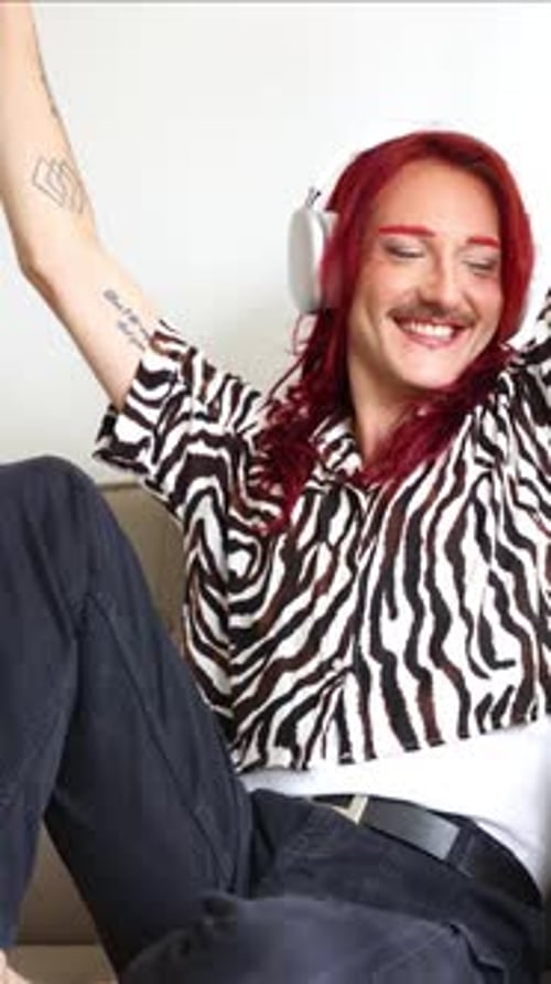 vertical Non-binary person enjoying music with headphones, celebrating self-acceptance