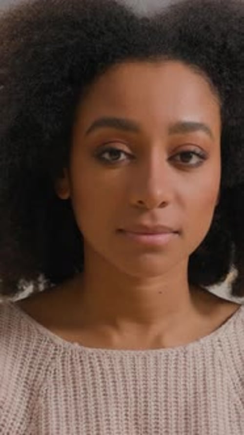 Close-up of woman with natural curly hair looking