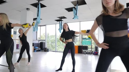 Women Exercising with Weights in Bright Gymnasium
