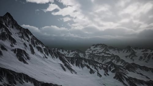 Majestic Winter Mountain Range Flyover Under Dramatic Sky