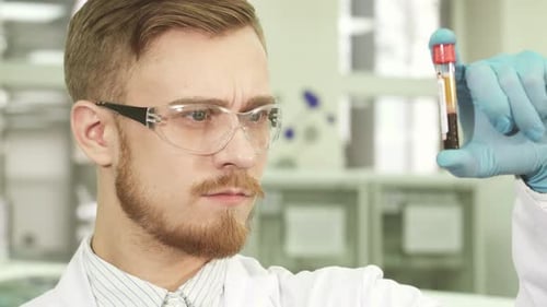 Young Scientist Examines Blood Sample in Test Tube