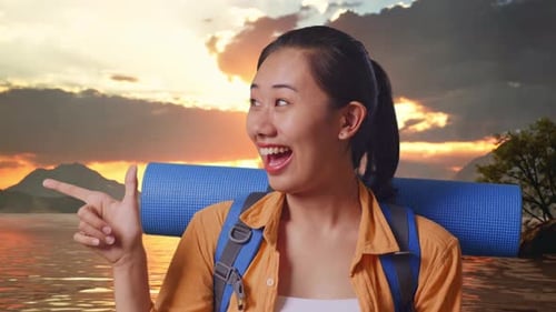 Close Up Of Asian Female Hiker Smiling And Pointing To Side At A Lake