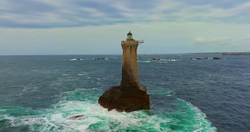 Una imagen aérea giratoria de Phare Du Four, un faro en Bretaña, Francia, un faro antiguo en pie
