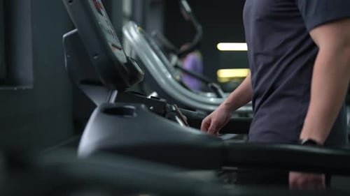 Cropped Shot of Unrecognizable Athletic Man Walking on Treadmill Preforming Warmingup Run Routine
