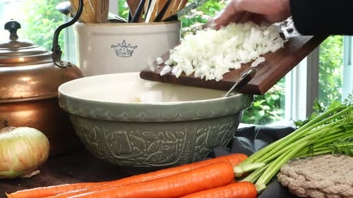 Making meatballs for Italian Wedding Soup. Adding yellow diced onions or shallots into a big green c
