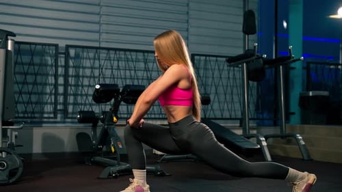 in the Gym Young Beautiful Girl in a Pink Top Does Stretching Before Training