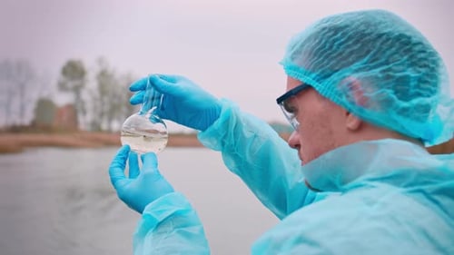 Scientist Analyzes Water Sample in Round Bottom Flask