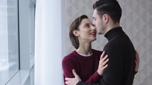 Smiling Couple Embracing in Modern Apartment