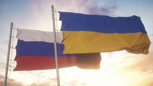 Waving Flags of Ukraine and Russia Against a Sunset Sky