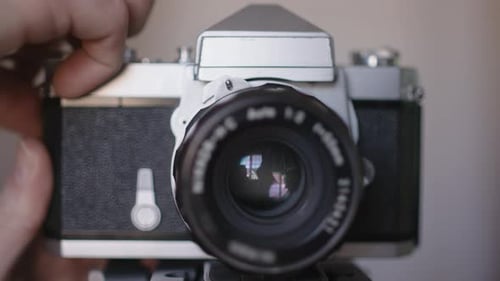 Camera shutter closing and opening as someone takes a photo with a classic film camera