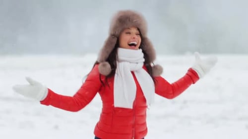 Joyful Woman Enjoying Snowfall in Winter Landscape