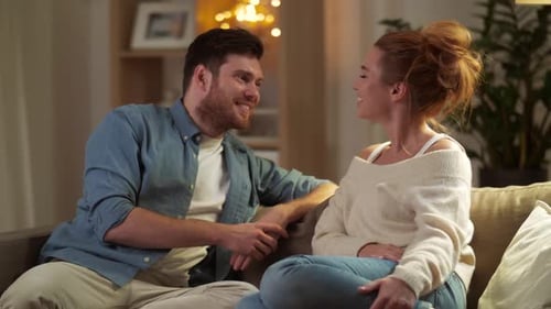 Smiling Couple Conversing on Sofa in Living Room