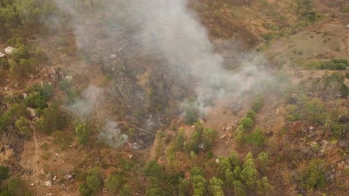 Smoke Billows from Wildfire Damaged Hillside