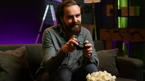 Man Plays Video Game on Couch at Home