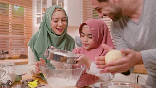 Happy Muslim family baking bakery together in kitchen at cozy home.