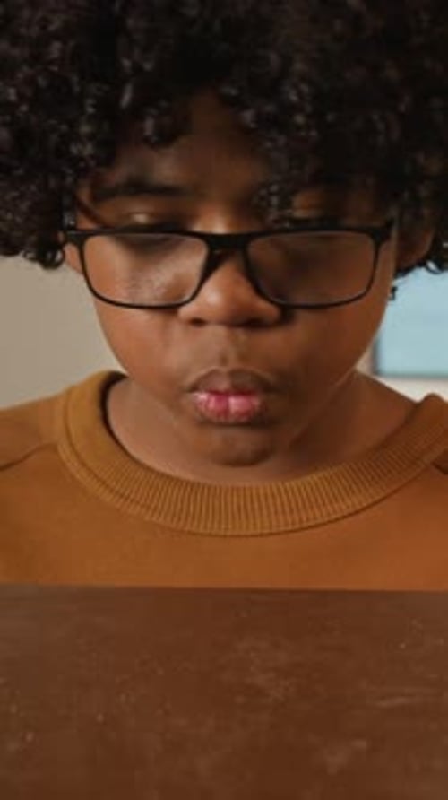 Vertical of Black Student Dusting Off Textbook for Returning Back to School