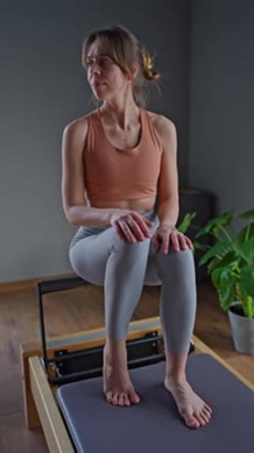 Woman Training Pilates on the Reformer Bed Reformer Pilates Studio Machine for Fitness Workouts in