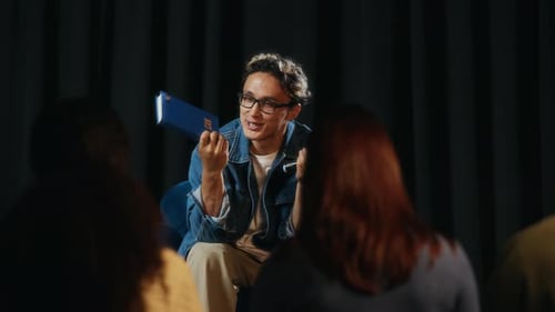 Young Confident Asian Author Giving Motivational Speech Presenting New Book
