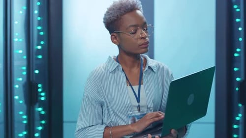 A Focused and Dedicated Professional Engaged in Working on a Laptop in a Modern Office Setting