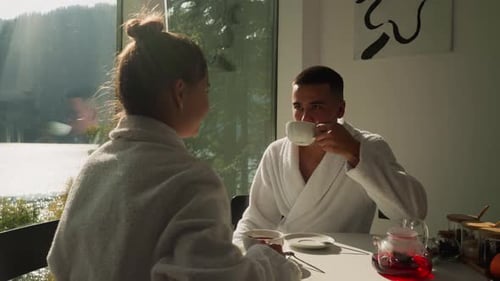 Marido bebe chá admirando a jovem esposa