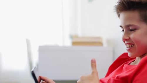 Boy using tablet device indoors, smiling face
