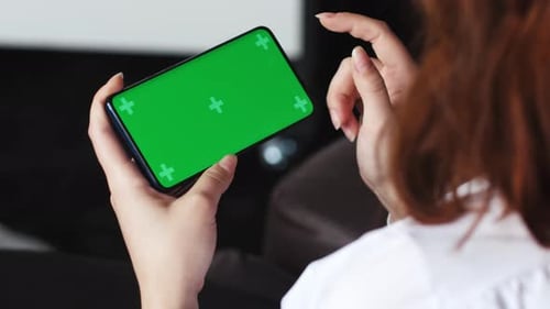 Woman Using Smartphone Watching Green Screen on Mobile Phone in Horizontal Orientation Person