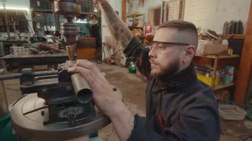 Mechaniker bedient die Bohrmaschine während der Metallbearbeitung