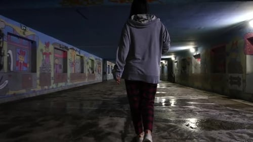 Girl walking in a corridor total shot