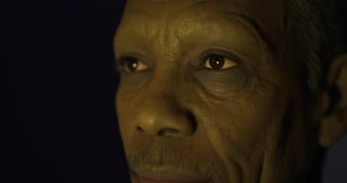 Close Up of an Elderly Man with Thoughtful Expression Against a Dark Background