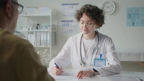 Female Doctor Taking Medical History and Interviewing Patient in Clinic