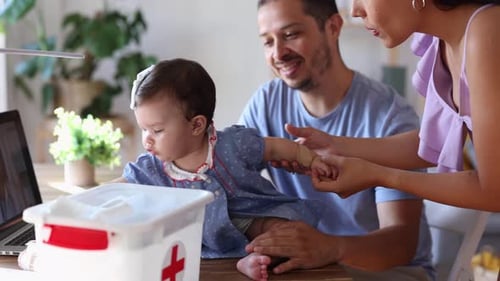 parents taking care of their baby with first aid kit