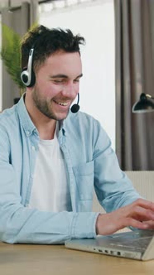 Smiling Man Video Calling on Laptop Indoors