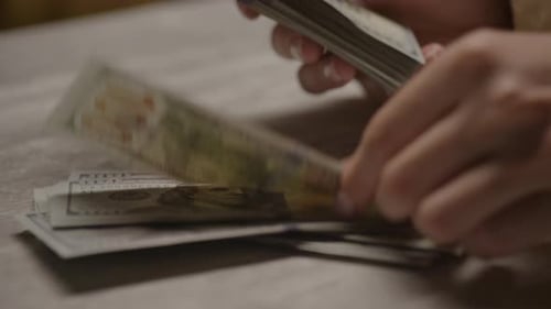 Adult Counting Currency at Home