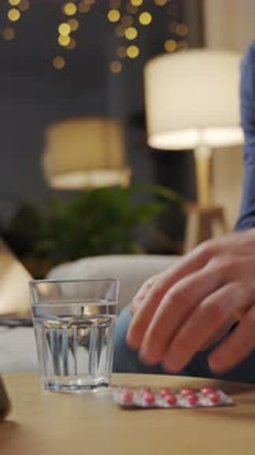Man Taking Medicine with Water in Home Setting