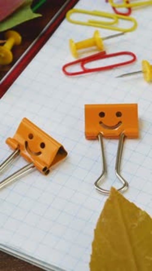 Office Supplies Scattered with Autumn Leaves on Paper Notepad