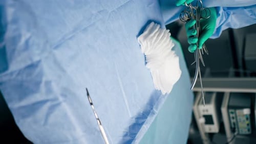 Vertical Video Closeup in Operating Room the Lower Surgeon in Green Gloves Lays Out Instruments on