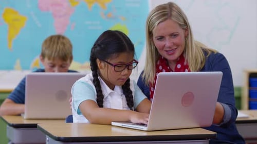 Teacher and Student Using Laptop Computer in Classroom