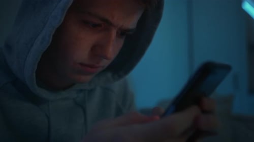 Teenager Using Smartphone Device at Night Indoors