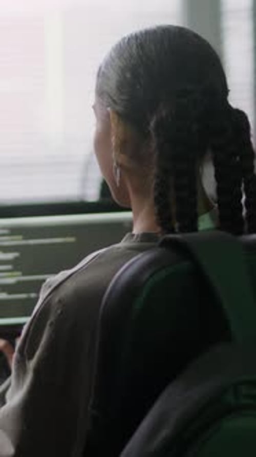 Vertikale einer jungen Programmiererin, die im Büro tippen lernt