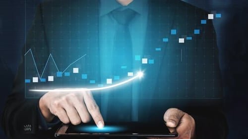 Businessman Analyzing Stock Market Trends on Digital Tablet with Financial Graphs and Data Visualiza