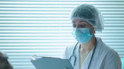 Female Doctor in Protective Uniform Visiting Patient in Hospital Ward