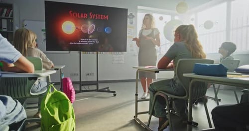Astronomy Class Female Teacher Explaining Solar System to Primary School Children Using Digital