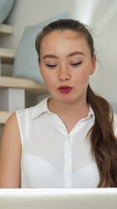 Woman Video Conferencing on Laptop at Home