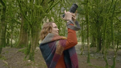 Female Photographer Capturing Images in Lush Forest