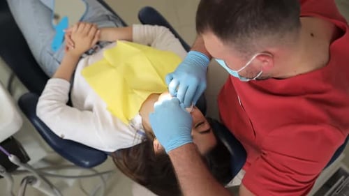 Medical Professional Works on Patient in Dental Chair